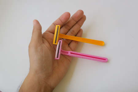 used pink and yellow beard razor on white isolated background photoの写真素材