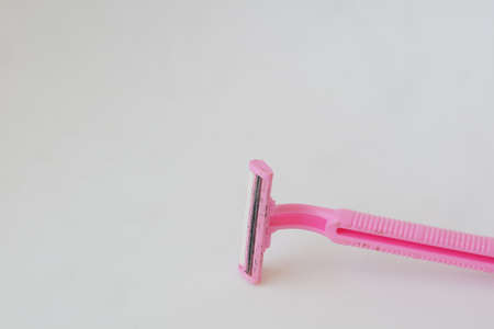 used pink beard razor on white isolated background photoの写真素材