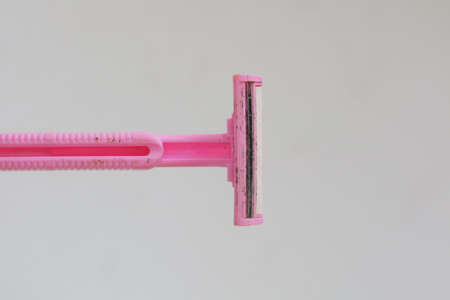 used pink beard razor on white isolated background photo