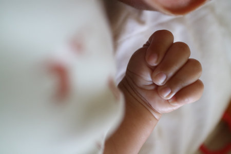 a photo of one hand of a newborn in a grasping position with the thumb insideの写真素材