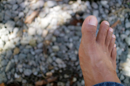 a photo of a man legs in dark brown. Asian man. gravel background