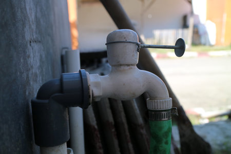 Photo of a water tap made of plastic, with the lever broken and replaced with a thumbtackの写真素材