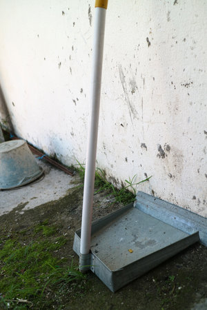 Photo of a dustpan made of zinc or light steel sheet, is outside the house.の写真素材