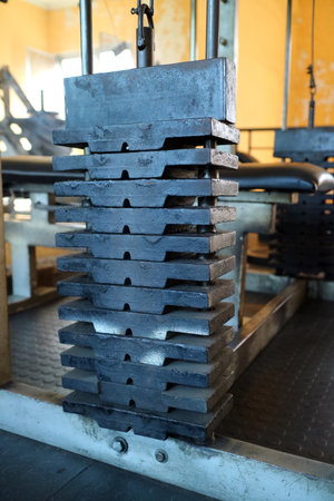A close up view of stacked weight plates in a gym setting, showcasing the texture and structure of...
