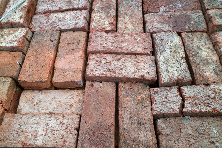 Close up of weathered red bricks arranged in a herringbone pattern.の写真素材