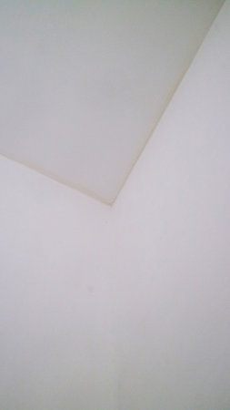 Minimalist image of a white ceiling corner with soft lighting.の写真素材