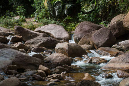 Water Flows Through Rocks In a mountain stream at Phrom Lok Waterfall, Khao Luang National Park in...