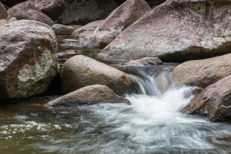 Water Flows Through Rocks In a mountain stream at Phrom Lok Waterfall, Khao Luang National Park in...