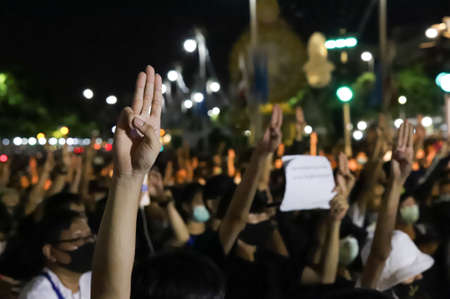 Bangkok, THAILAND - August 16, 2020: Protesters a three finger salute to show symbolic gestures at Democracy Monument to protest against the government, demand for new constitution and monarchy reform.のeditorial素材