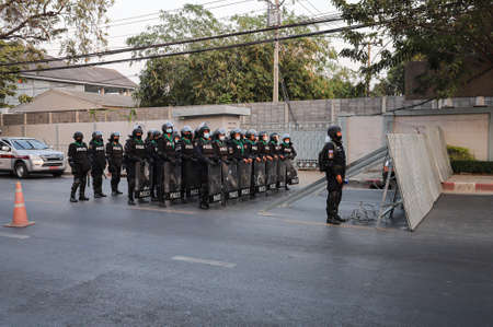 Bangkok, THAILAND - February 19, 2021: Riot Police stand guard to protect Sappaya-Sapasathan from...