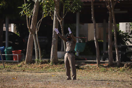 Songkhla , THAILAND - March 5, 2021: Police marshaller is Marshalling signals to Helicopter Landing at Field between Deputy Minister of Agriculture and Cooperatives inspection program.のeditorial素材
