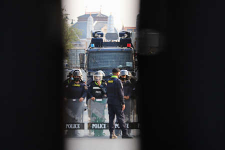 Bangkok, THAILAND - March 20, 2021: High-pressure water cannon truck standby behind the containers blocking by Thai Government for protect Restricted area from Pro-democracy Protesters.のeditorial素材