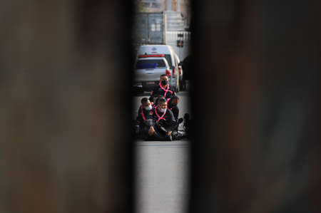 Bangkok, THAILAND - March 20, 2021: à¸ºRiot police rest behind the containers blocking by Thai...