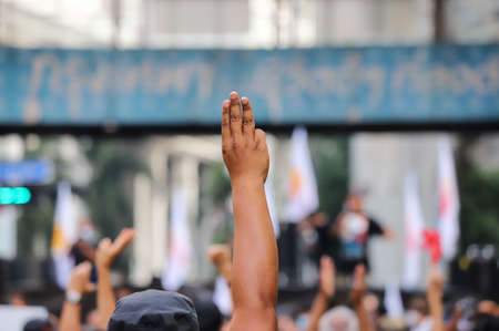 Bangkok, THAILAND - March 24, 2021: Pro-democracy protesters a three finger salute to show symbolic gestures at Ratchaprasong intersection to protests for right to bail protesters and monarchy reform.のeditorial素材