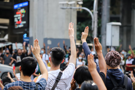 Bangkok, THAILAND - March 24, 2021: Pro-democracy protesters a three finger salute to show symbolic gestures at Ratchaprasong intersection to protests for right to bail protesters and monarchy reform.のeditorial素材