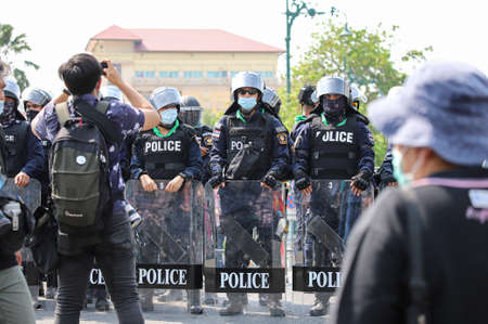 Bangkok, THAILAND - March 30, 2021: Riot police stand guard with shield to protect the government house during Pro-democracy demonstrators group photo symbolic parody new cabinet.のeditorial素材