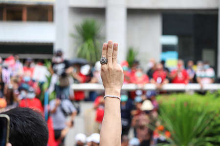 Bangkok, THAILAND - April 10, 2021: UDD Red shirt a three finger salute to show symbolic gestures on commemorate the 11th anniversary of the violent crackdown on red-shirt protesters by government.のeditorial素材