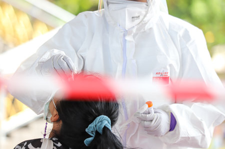 Bangkok, THAILAND - May 17, 2021: The medical worker wearing PPE to Nasal Swab Specimen for COVID-19 Testing from the people at Rama VIII Bridge in The BMA Health Department mobile screening unit.のeditorial素材