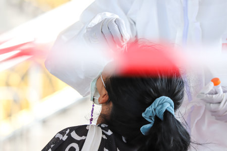Bangkok, THAILAND - May 17, 2021: The medical worker wearing PPE to Nasal Swab Specimen for COVID-19...