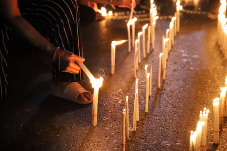 Bangkok, THAILAND - June 24, 2021: Pro-democracy protesters light a candle to memorial Siamese revolution of 1932 in the dawn at Democracy Monument.のeditorial素材