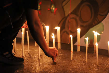 Bangkok, THAILAND - June 24, 2021: Pro-democracy protesters light a candle to memorial Siamese revolution of 1932 in the dawn at Democracy Monument.のeditorial素材