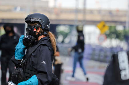 Bangkok, THAILAND - August 7, 2021: Riot police block road to 1st Infantry Regiment by container and crackdown protesters by tear gas, rubber bullets, water cannon.のeditorial素材