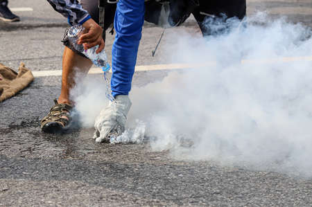 Bangkok, THAILAND - August 7, 2021: Riot police block road to 1st Infantry Regiment by container and crackdown protesters by tear gas, rubber bullets, water cannon.のeditorial素材