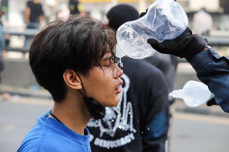Bangkok, THAILAND - August 7, 2021: Riot police block road to 1st Infantry Regiment by container and crackdown protesters by tear gas, rubber bullets, water cannon.のeditorial素材