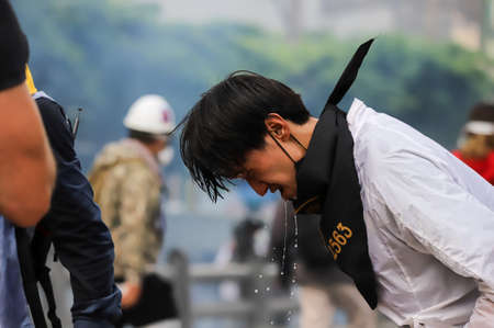 Bangkok, THAILAND - August 7, 2021: Riot police block road to 1st Infantry Regiment by container and crack down protesters by tear gas, rubber bullets, water cannon.のeditorial素材