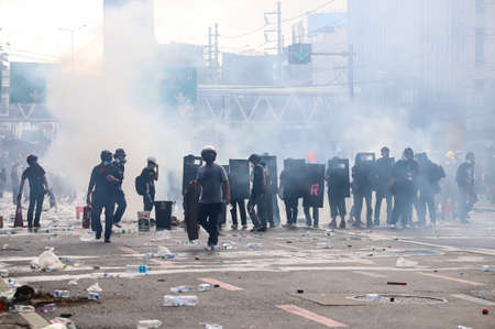 Bangkok, THAILAND - August 7, 2021: Riot police block road to 1st Infantry Regiment by container and...
