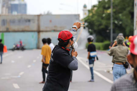 Bangkok, THAILAND - August 13, 2021: Protesters retaliate riot police by slingshot and fireworks after riot police shoot tear gas and rubber bullets for crackdown.のeditorial素材