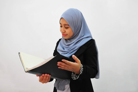 Young businesswoman see a report book with white backgroundの写真素材