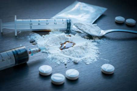 Drug syringe and cooked heroin on spoon