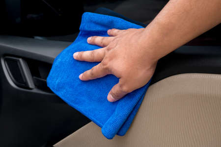 Hand cleaning interior car door panel with microfiber clothの写真素材