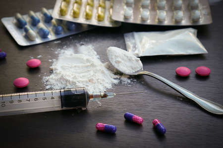 Drug syringe and cooked heroin on spoon