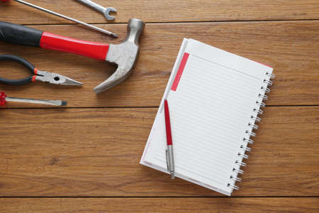 Set of tools on cork panel background with notepad for copy space