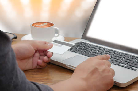 man's hands holding a credit card and using smart phone for online shopping.Vintage or retro color...