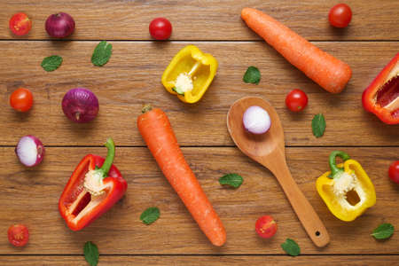 Colorful organic vegetables with wooden spoon , ingredients for salad or filling on rustic wooden background, top view. Healthy food or diet cooking concept, Vegetarian or diet foodの写真素材