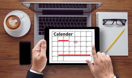 Calender Planner Organization Management Remind Concept, on tablet pc screen held by businessman hands - concept, top view computer, phone ,coffee, Warm toneの写真素材
