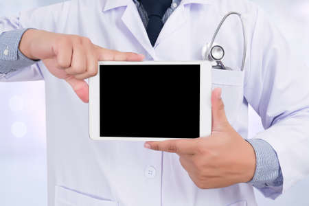 Doctor holding blank digital tablet with copy space and clipping path for the screenの写真素材