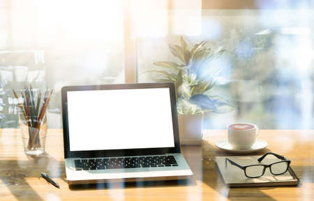 Office workplace with laptop and smart phone on wood table and blurred backgroundの写真素材