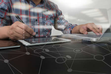designer working digital tablet and computer laptop and digital design diagram on wooden desk as...