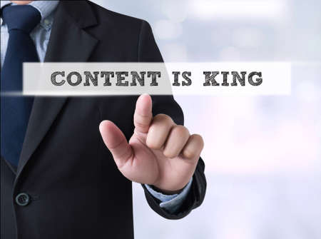 CONTENT IS KING, Businessman touching a touch screen on blurred city backgroundの写真素材