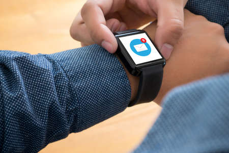 man Hand , email icon on smartwatch  in cafe bar. High angle shot. Toned image.の写真素材