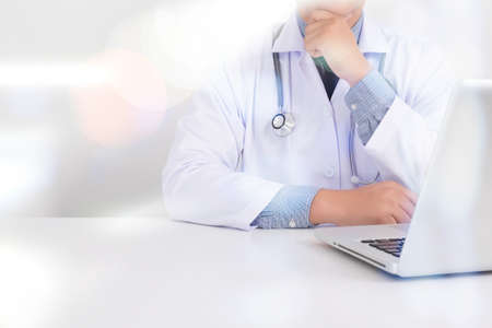 Portrait of a male handsome doctor thinking, medical doctor working with abstract blurry bokeh background as conceptの写真素材