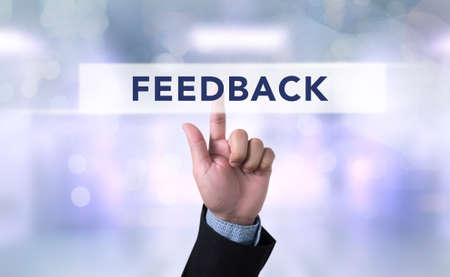 Business man with hand pressing a button on blurred abstract background, Feedback conceptの写真素材