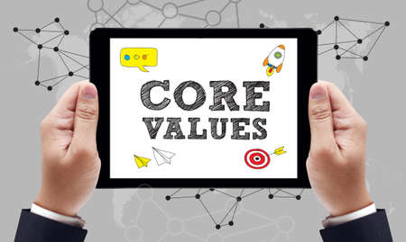 Core Values Concept on the tablet pc screen held by businessman hands - online, top viewの写真素材