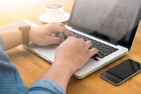 Cropped image of a young man working on his laptop in a coffee shop businessman using technology