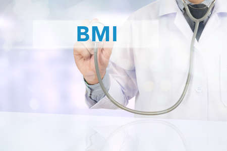 BMI body mass index Close up of a male doctor in scrubs using digital tablet.の写真素材