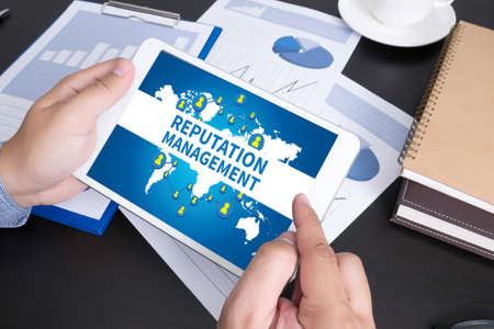 Modern people doing business, graphs and charts being demonstrated on the screen of a touch-pad,REPUTATION MANAGEMENT CONCEPTの写真素材